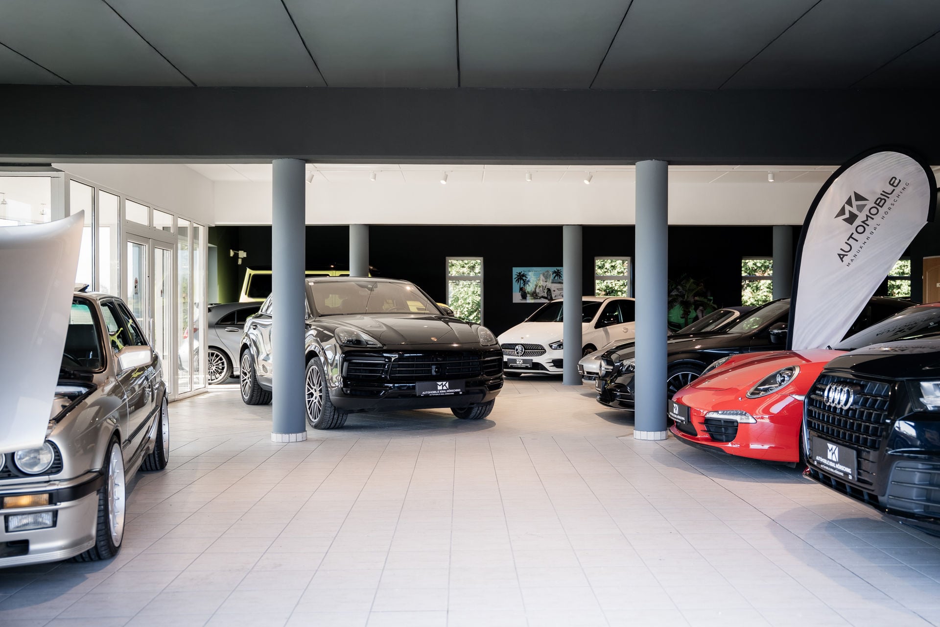 Showroom von M.K. Automobile mit Porsche Cayenne und Porsche 911
